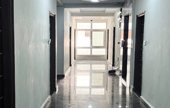 Upper floor corridor at Casavir PG in Madhapur, bright marble finish, room entries visible